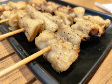 Mangalda tavuk derisi. Genellikle Yakitori olarak hazırlanan gevrek, lezzetli ısırıklar yaratır.