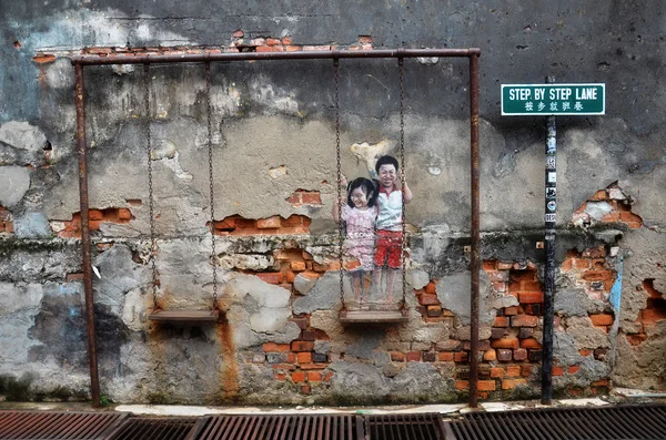 Уличная фреска "Дети на качелях", написанная Луи Ганом и — стоковое фото