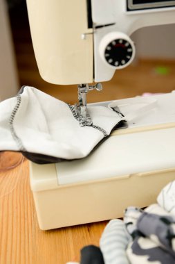 Coronavirus teması. Evde koruyucu maskeler yapmak. Dikiş makinesi ve bez parçaları üretim aşamasında. DIY Ev yapımı Covid-19 'a karşı pandemik koruma için.