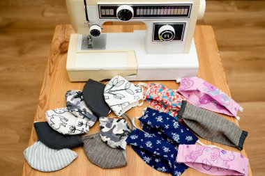 Coronavirus teması. Evde koruyucu maskeler yapmak. Dikiş makinesi ve bez parçaları üretim aşamasında. DIY Ev yapımı Covid-19 'a karşı pandemik koruma için.