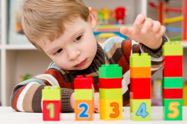 Saymayı öğreniyorum. Duplo bloklarını istifleyen 2 yaşında bir çocuk. Çocuklar, bebeklik ve eğitim konsepti. Çocuğun oluşumu ve gelişimi. Montessori ve erken gelişim
