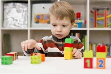 Saymayı öğreniyorum. Duplo bloklarını istifleyen 2 yaşında bir çocuk. Çocuklar, bebeklik ve eğitim konsepti. Çocuğun oluşumu ve gelişimi. Montessori ve erken gelişim