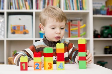 Saymayı öğreniyorum. Duplo bloklarını istifleyen 2 yaşında bir çocuk. Çocuklar, bebeklik ve eğitim konsepti. Çocuğun oluşumu ve gelişimi. Montessori ve erken gelişim