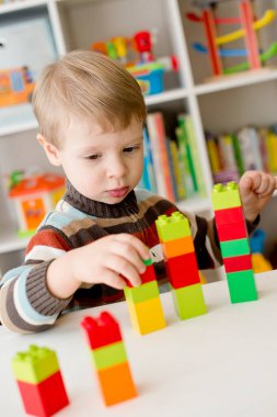 Saymayı öğreniyorum. Duplo bloklarını istifleyen 2 yaşında bir çocuk. Çocuklar, bebeklik ve eğitim konsepti. Çocuğun oluşumu ve gelişimi. Montessori ve erken gelişim