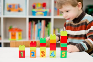 Saymayı öğreniyorum. Duplo bloklarını istifleyen 2 yaşında bir çocuk. Çocuklar, bebeklik ve eğitim konsepti. Çocuğun oluşumu ve gelişimi. Montessori ve erken gelişim