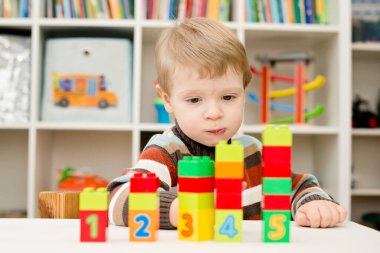 Saymayı öğreniyorum. Duplo bloklarını istifleyen 2 yaşında bir çocuk. Çocuklar, bebeklik ve eğitim konsepti. Çocuğun oluşumu ve gelişimi. Montessori ve erken gelişim