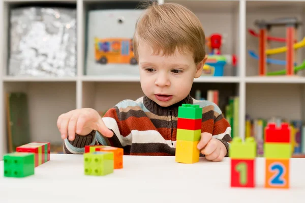 Saymayı öğreniyorum. Duplo bloklarını istifleyen 2 yaşında bir çocuk. Çocuklar, bebeklik ve eğitim konsepti. Çocuğun oluşumu ve gelişimi. Montessori ve erken gelişim