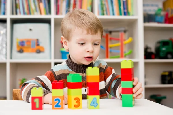 Saymayı öğreniyorum. Duplo bloklarını istifleyen 2 yaşında bir çocuk. Çocuklar, bebeklik ve eğitim konsepti. Çocuğun oluşumu ve gelişimi. Montessori ve erken gelişim
