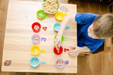 Küçük çocuk basit matematik egzersizleri yapıyor. Erken eğitim, sayma oyunu. Çocuklar için okul öncesi egzersizi. 1 'den 10' a sıralama.