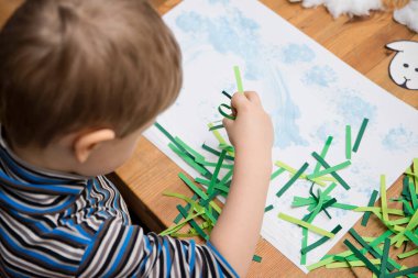 Anaokulu eğitimi, bağımsız çalışma, DIY görevi. Çocuk, doğal pamuktan koyun yapıyor. Erken öğrenme, konsantre görünüm.