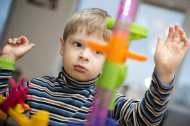 Hadi misket yarışı oynayalım. Çocuğun duygusal bir yüzü var. Evde çocukluk aktiviteleri. Anaokulu çocuğu top parkuruyla oynuyor.