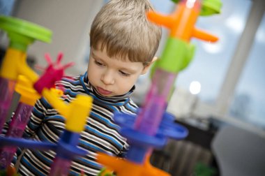 Hadi misket yarışı oynayalım. Çocuğun duygusal bir yüzü var. Evde çocukluk aktiviteleri. Anaokulu çocuğu top parkuruyla oynuyor.