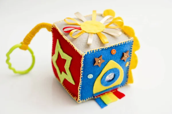 Bebekler ve bebekler için renkli bir el yapımı oyuncak. Yoğun küp. Yetenek ve motor becerileri geliştirmek için kumaştan yapılmış yumuşak bir bebek bloğu. Taggie Küpü. Montessori meşgul oyuncak.