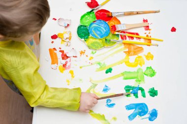 Doldurulmuş renkli keçeli mektuplar ve beyaz arka plan boyalı aynı renk fırça. Paskalya konsepti. Yumurta boyama teması. Görünür yumurtalar, çocuk elleri ve boyama süreci.