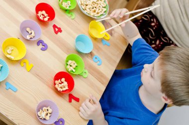 Küçük çocuk basit matematik egzersizleri yapıyor. Erken eğitim, sayma oyunu. Çocuklar için okul öncesi egzersizi. 1 'den 10' a kadar. Montessori matematik aracı. 