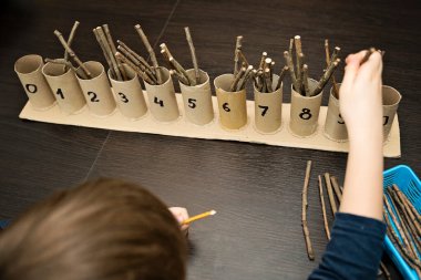 Küçük çocuk basit matematik egzersizleri yapıyor. Erken eğitim, sayma oyunu. Çocuklar için okul öncesi egzersizi. Çocuk ona kadar saymayı öğreniyor. Montessori matematik aracı.