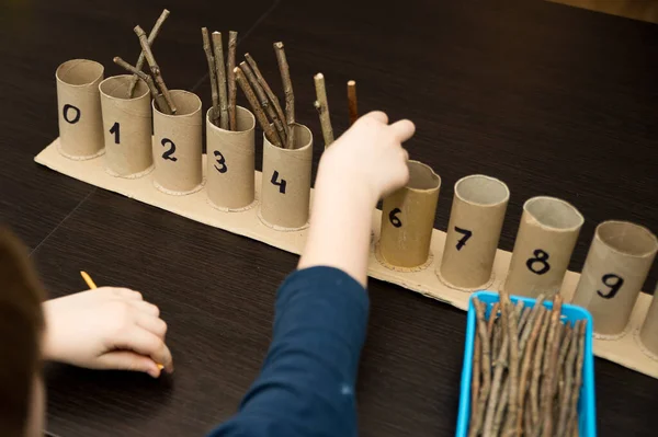 Küçük çocuk basit matematik egzersizleri yapıyor. Erken eğitim, sayma oyunu. Çocuklar için okul öncesi egzersizi. Çocuk ona kadar saymayı öğreniyor. Montessori matematik aracı.