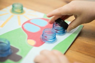 Ev yapımı yeni yürümeye başlayan bebek oyunu. Şişe bardaklarının doğru yerde vidalanması gerekir. Trafik ışığı, araba tekerlekleri ve güneş. İyi motor becerileri geliştirmek, mantıksal düşünce, el-göz koordinasyonu oyun yoluyla.