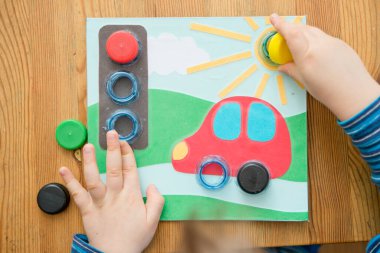 Ev yapımı yeni yürümeye başlayan bebek oyunu. Şişe bardaklarının doğru yerde vidalanması gerekir. Trafik ışığı, araba tekerlekleri ve güneş. İyi motor becerileri geliştirmek, mantıksal düşünce, el-göz koordinasyonu oyun yoluyla.