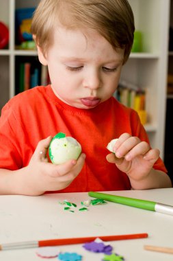 Renkli yumurta soyan küçük çocuk. Paskalya teması. Dini bir ziyafet.