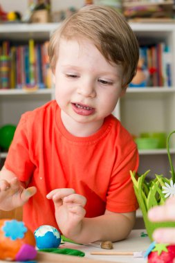Renkli yumurta soyan küçük çocuk. Paskalya teması. Dini bir ziyafet.