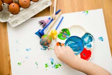 Mutlu Paskalyalar. Paskalya yumurtası boyayan 3 yaşında bir çocuk. Dini bayram. Erken eğitim ve sanatsal anaokulu aktiviteleri.