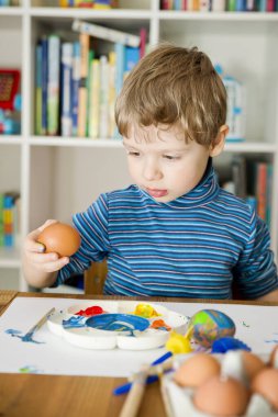Mutlu Paskalyalar. Paskalya yumurtası boyayan 3 yaşında bir çocuk. Dini bayram. Erken eğitim ve sanatsal anaokulu aktiviteleri.