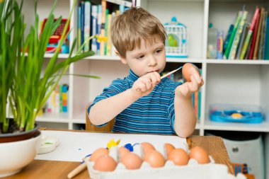 Mutlu Paskalyalar. Paskalya yumurtası boyayan 3 yaşında bir çocuk. Dini bayram. Erken eğitim ve sanatsal anaokulu aktiviteleri.