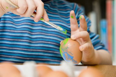 Mutlu Paskalyalar. Paskalya yumurtası boyayan 3 yaşında bir çocuk. Dini bayram. Erken eğitim ve sanatsal anaokulu aktiviteleri.