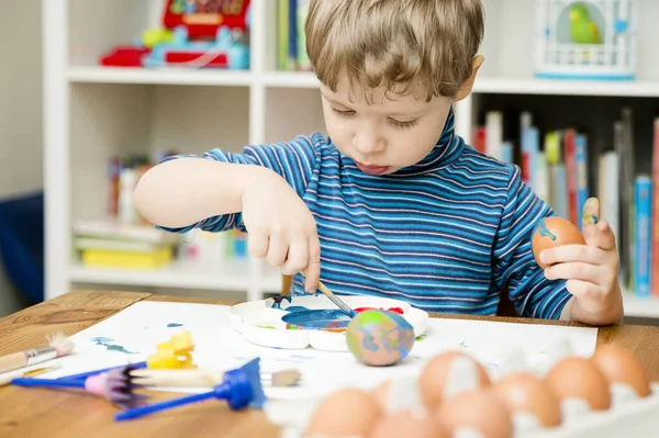 Mutlu Paskalyalar. Paskalya yumurtası boyayan 3 yaşında bir çocuk. Dini bayram. Erken eğitim ve sanatsal anaokulu aktiviteleri.