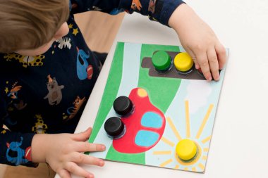 Ev yapımı yeni yürümeye başlayan bebek oyunu. Şişelerin doğru yerde vidalanması gerekiyor. Trafik ışığı, araba tekerlekleri ve güneş.