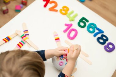 Erken eğitim için mantık ve sayma oyunu. Keçeli kalem numaraları ve üzerinde saç bağı sakızı olan çubuklar. Her buzlu dondurmada özel yüzük sayısı var..