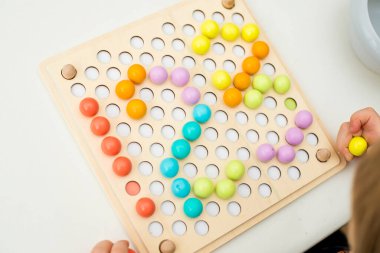 123, çocuk sayı yaratmak için pimi yerleştiriyor. İyi motor becerileri, matematiksel temel.