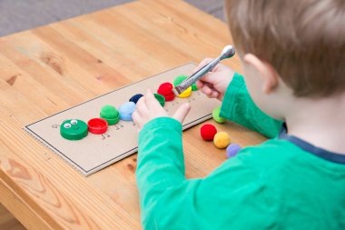 Plastik şişe kapağı solucanı. Doğru renk ponponları kırkayak tırtılına koyun. 5 dakikalık aralıklarla. Çocuk yuvası aktivitesi. Erken eğitim, iyi motor becerileri..