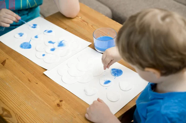 Let's make the rain. Boy coloring drop shape cotton pads. 5 minute crafts for children activities. Creative solutions at home.