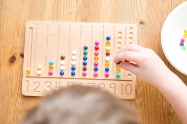 Montessori Boncuklar Kurulu. Sayıları saymayı ve yazmayı öğrenmek, çocuğu zihinsel aritmetiğe hazırlamak, bir düzen, odaklanma, koordinasyon ve doğruluk duygusu geliştirmek.