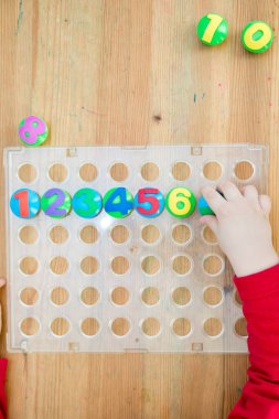 Oyun sayıyorum. Belirtilen numaraya göre doğru sayıda kapak al. Küçük çocuk görevini yerine getirdi. Erken eğitim. Oyuncak hayal gücünü, yaratıcılığı, el-göz koordinasyonunu canlandırır..