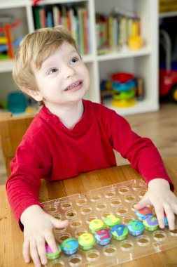Oyun sayıyorum. Belirtilen numaraya göre doğru sayıda kapak al. Küçük çocuk görevini yerine getirdi. Erken eğitim. Oyuncak hayal gücünü, yaratıcılığı, el-göz koordinasyonunu canlandırır..