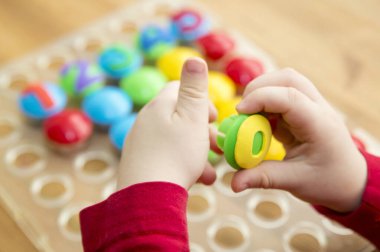 Oyun sayıyorum. Belirtilen numaraya göre doğru sayıda kapak al. Küçük çocuk görevini yerine getirdi. Erken eğitim. Oyuncak hayal gücünü, yaratıcılığı, el-göz koordinasyonunu canlandırır..