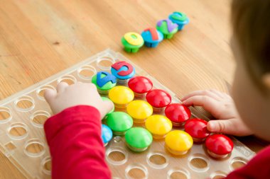 Oyun sayıyorum. Belirtilen numaraya göre doğru sayıda kapak al. Küçük çocuk görevini yerine getirdi. Erken eğitim. Oyuncak hayal gücünü, yaratıcılığı, el-göz koordinasyonunu canlandırır..