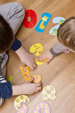 Yeni yürümeye başlayan çocuk yerde oyuncak numaralarıyla oynuyor. Entelektüel matematik oyunu, erken eğitim için anaokulu uygulaması.