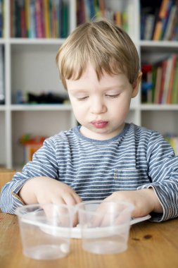 Böbrek fasulyesini beyaz fasulyeden ayıran çocuk. Montessori konsepti. Erken eğitim için anaokulu uygulaması. İyi motor becerileri ve dikkat alıştırması. Çocuk ev konseptiyle oynuyor..