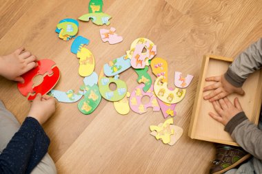 Yeni yürümeye başlayan çocuk yerde oyuncak numaralarıyla oynuyor. Entelektüel matematik oyunu, erken eğitim için anaokulu uygulaması.