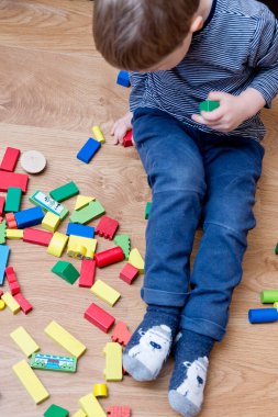 Genç bir inşaatçı. Çocuk ahşap bloklardan şehir inşa ediyor. Çocuk Oyun Odası. Geliştirme ve İnşaat Konsepti. Öğrenme oyuncağı hayal gücünü, yaratıcılığı, el-göz koordinasyonunu canlandırır..