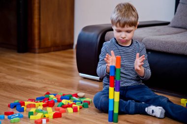 Genç bir inşaatçı. Çocuk ahşap bloklardan şehir inşa ediyor. Çocuk Oyun Odası. Geliştirme ve İnşaat Konsepti. Öğrenme oyuncağı hayal gücünü, yaratıcılığı, el-göz koordinasyonunu canlandırır..