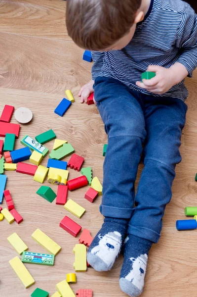 Genç bir inşaatçı. Çocuk ahşap bloklardan şehir inşa ediyor. Çocuk Oyun Odası. Geliştirme ve İnşaat Konsepti. Öğrenme oyuncağı hayal gücünü, yaratıcılığı, el-göz koordinasyonunu canlandırır..