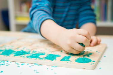 Çocuk oyun yoluyla numaraları öğreniyor. Renkli pirinç ve ahşap sayılarda duyusal aktivite. Evde eğitim, okul öncesi eğitim, Montessori metodu