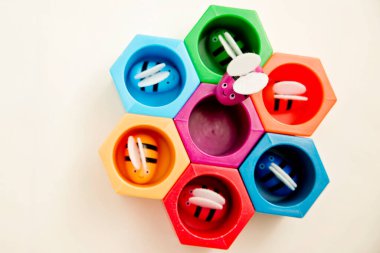 Cımbızlı bebekler için oyuncaklar. Renkli arı kovanı. Bal peteğindeki arılar. Parlak gökkuşağı renkli. Küçükler için okul öncesi oyunu. Montessori eğitimi.