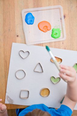 Çocuk geometrik şekilleri öğreniyor. Güzel motor beceriler. Anaokulu ya da özel görevler. Çocukların erken eğitimi. Montessori yöntembilimi.