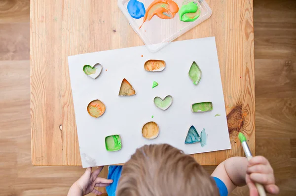 Çocuk geometrik şekilleri öğreniyor. Güzel motor beceriler. Anaokulu ya da özel görevler. Çocukların erken eğitimi. Montessori yöntembilimi.
